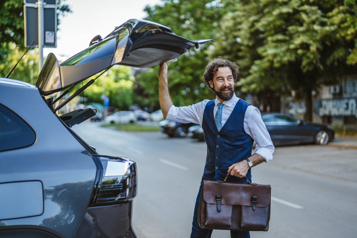 Australian self-employed business professional loading a briefcase into a modern grey car, representing ABN holders, sole traders and contractors seeking business vehicle finance